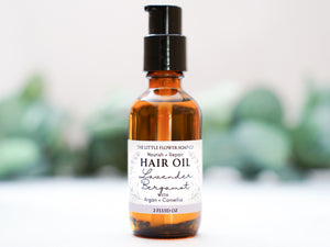 Bottle of repair natural hair oil with argan and camellia oils in lavender bergamot essential oil scent a label on a white background