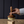Load image into Gallery viewer, Hand holding the luxe b. high end wooden dish washing brush over a block of soap on a wooden surface with a dark background
