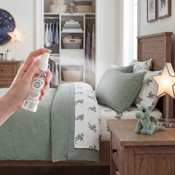 a picture of a mom spraying dragon dreams monster be gone essential oil spray around her kids room as part of the bedtime ritual the bed has a sage green dragon theme 