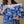 Load image into Gallery viewer, A woman wearing a blue floral dress holds a blue and white floral textured pouch or sleeve with a small 'MYPASH' label, against a plain beige background.
